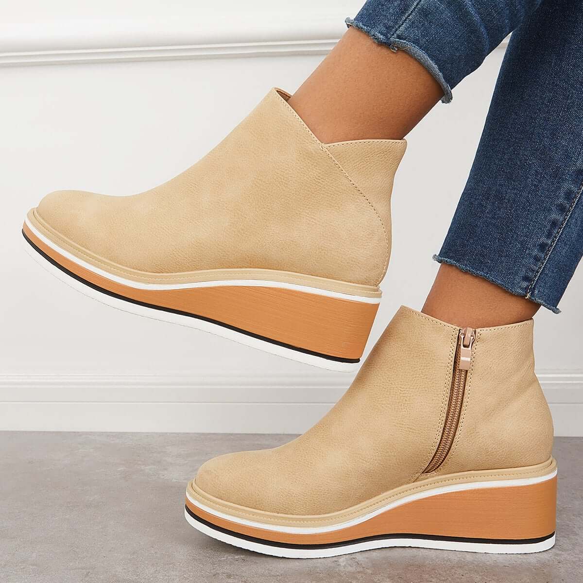 Damen-Stiefeletten aus braunem Leder mit Keilabsatz, Reißverschluss und sportlichem Design. Perfekt für Herbstmode und bequemen Alltagsstil.