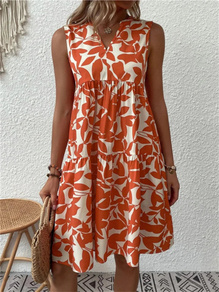 Armelloses kleid mit stufenrock und blattmuster