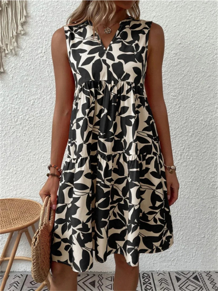 Armelloses kleid mit stufenrock und blattmuster