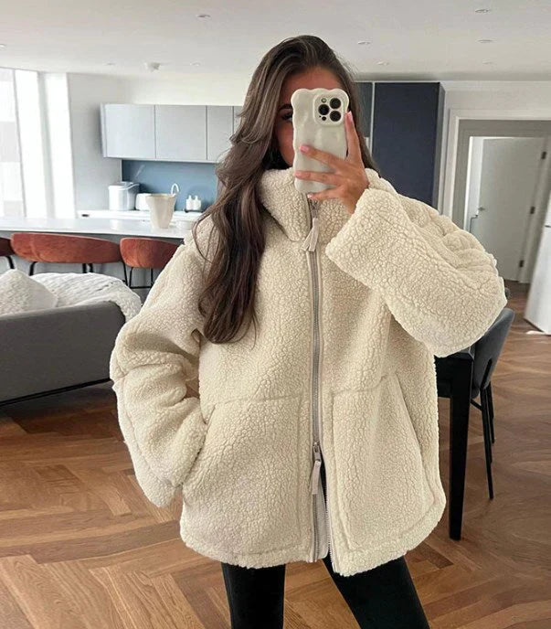Beige lammwolljacke auf weißem hintergrund